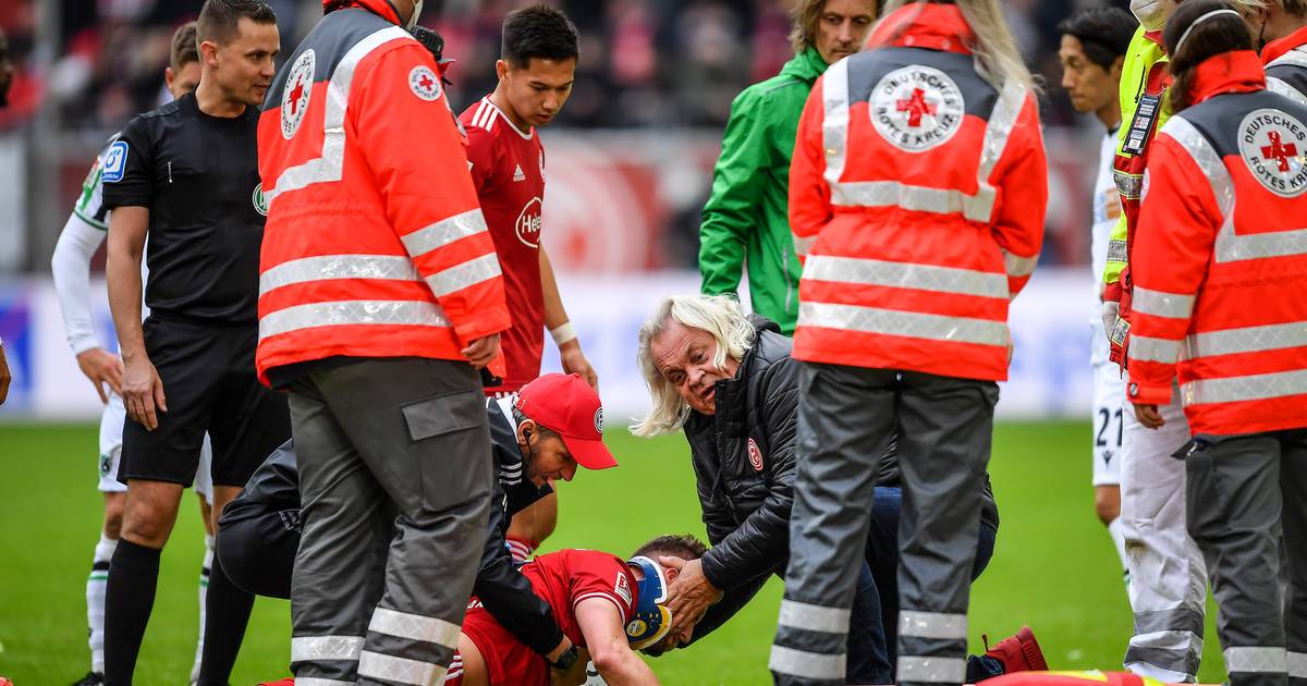 First aid on the pitch: Andre Hoffmann surrounded by assistants.